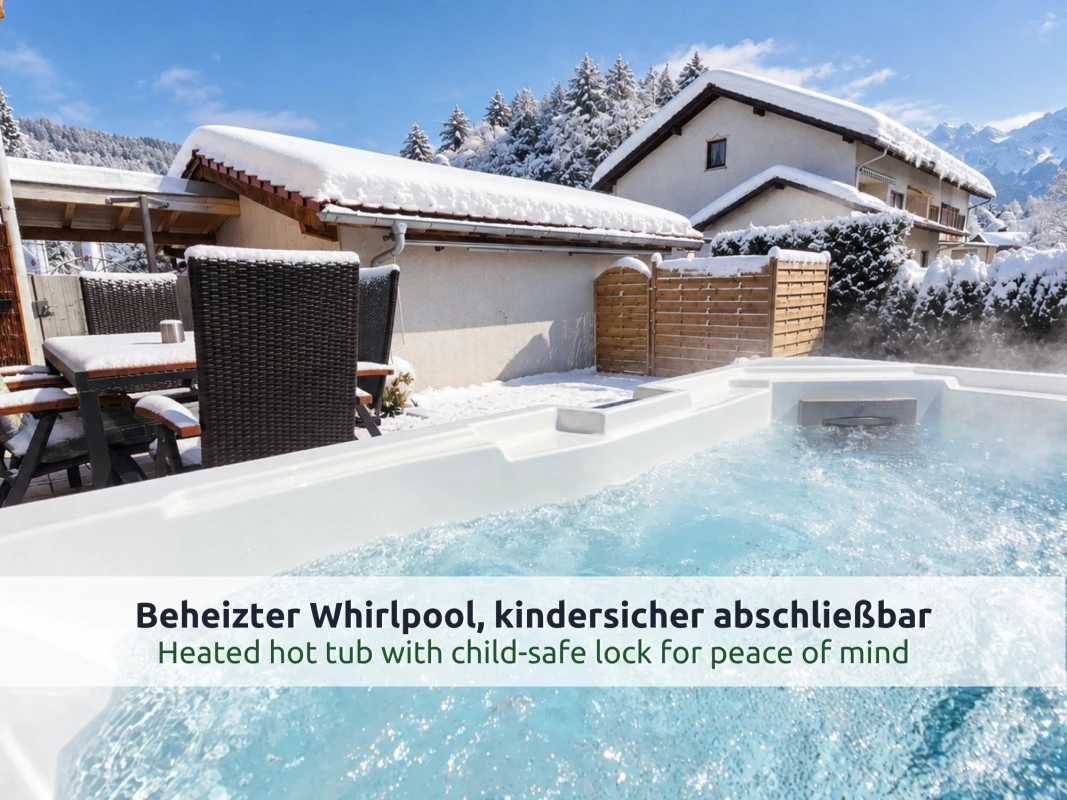 01 Ferienhaus Ruhpolding: dampfender Whirlpool auf der verschneiten Terrasse mit Bergblick