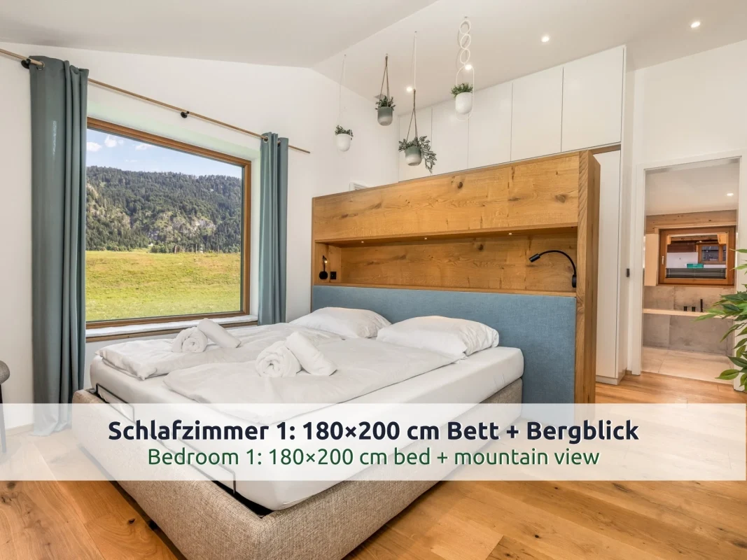 Chalet Reit im Winkl: Schlafzimmer mit Doppelbett und großem Fenster mit Blick auf Wiese und Berg