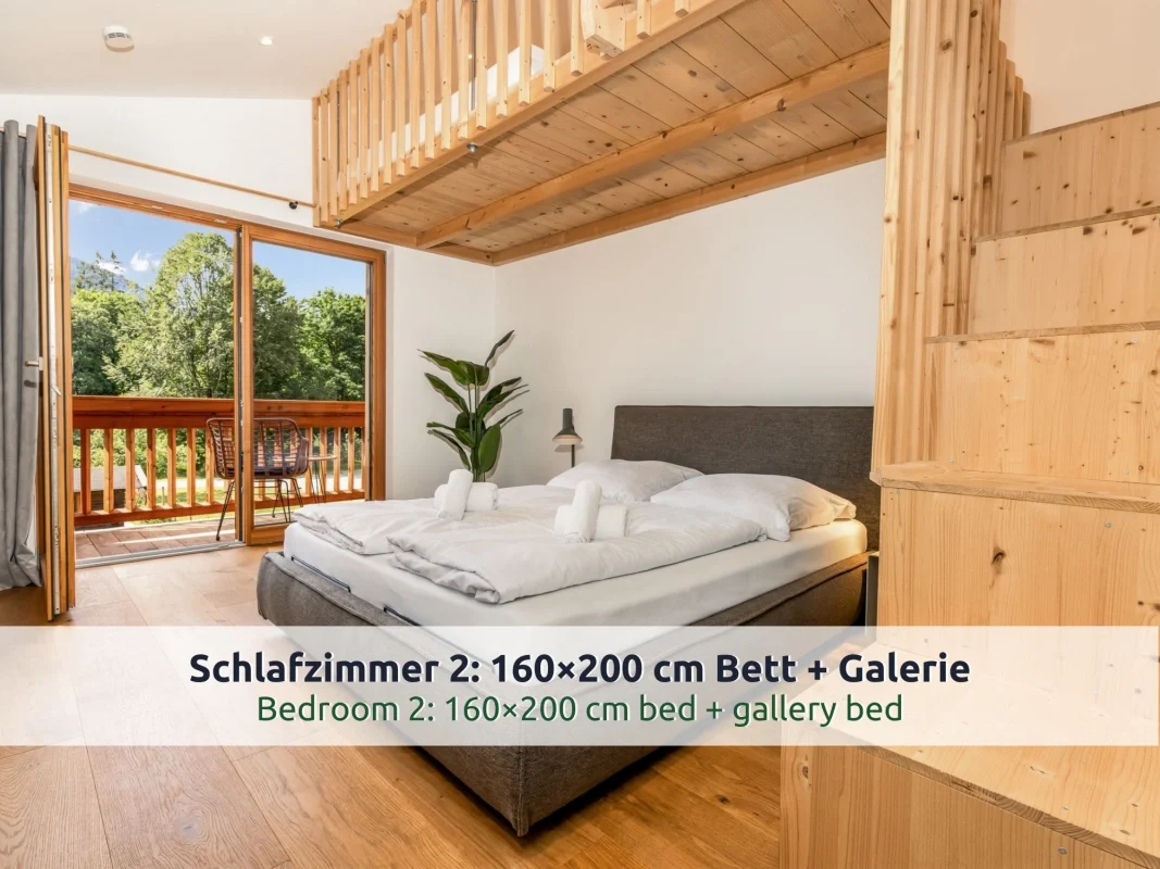 Chalet Reit im Winkl: Schlafzimmer mit Doppelbett, Holztreppe zur Galerie und offener Balkontür