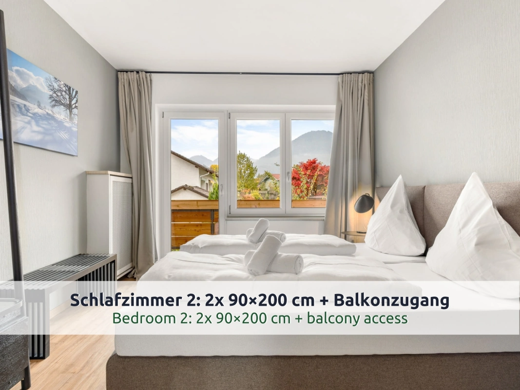 Ferienhaus Ruhpolding: zweites Schlafzimmer mit zusammengeschobenen Betten, Leselampe, Holzbank und Fenster mit Bergblick