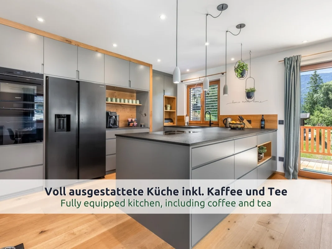 Chalet Reit im Winkl: Küche mit grauer Kochinsel, großem Kühlschrank, Einbaubacköfen und Kaffeevollautomat