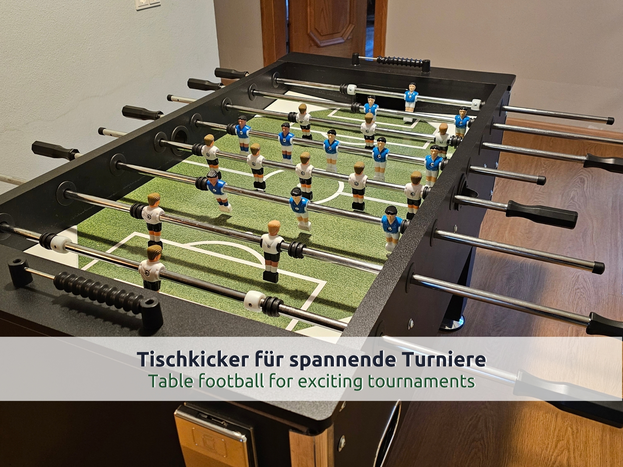 21 Villa Siegsdorf: Tischkicker mit blauen und weißen Spielfiguren im Spielzimmer, dahinter eine Holztür