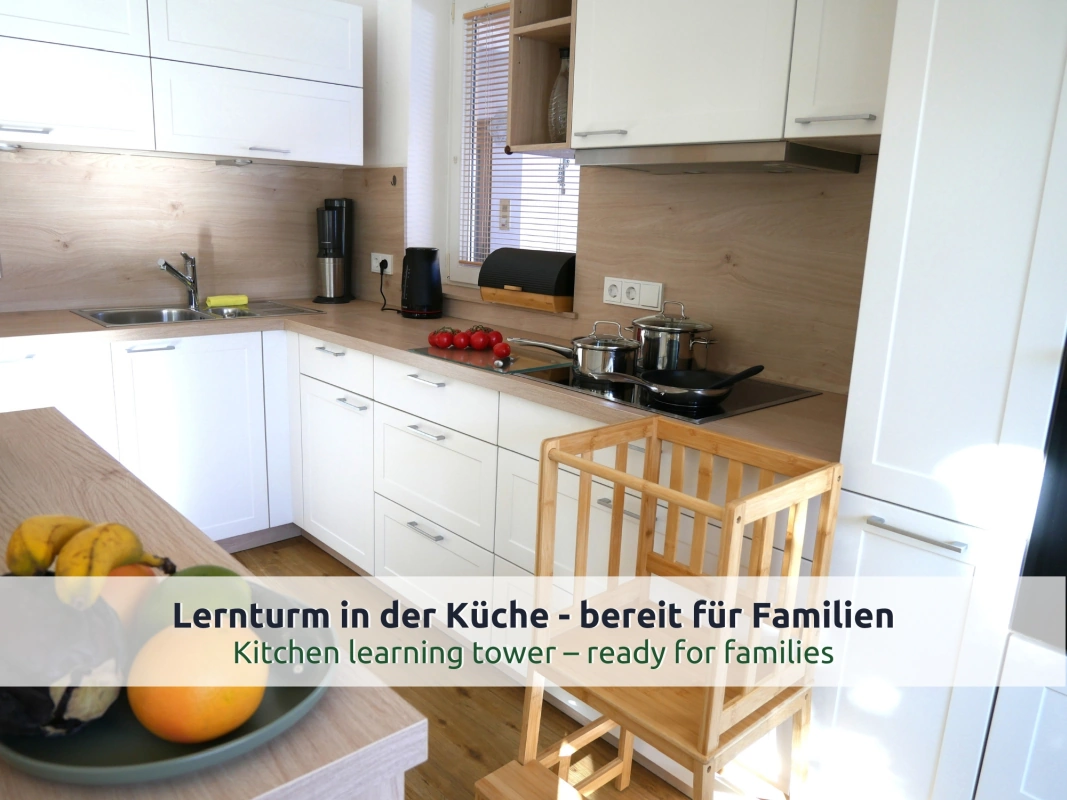 26 Ferienhaus Ruhpolding: Lernturm aus Holz für Kinder an der Küchenarbeitsfläche neben dem Kochfeld