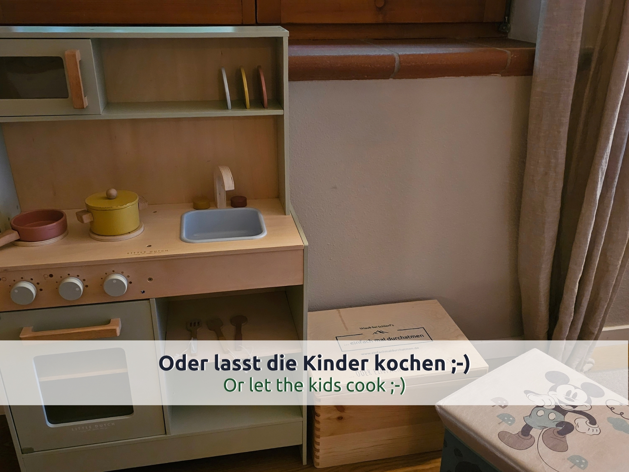 27 Villa Siegsdorf: Kinderküche aus Holz mit Töpfen, Spüle und Backofen, daneben eine Holzkiste