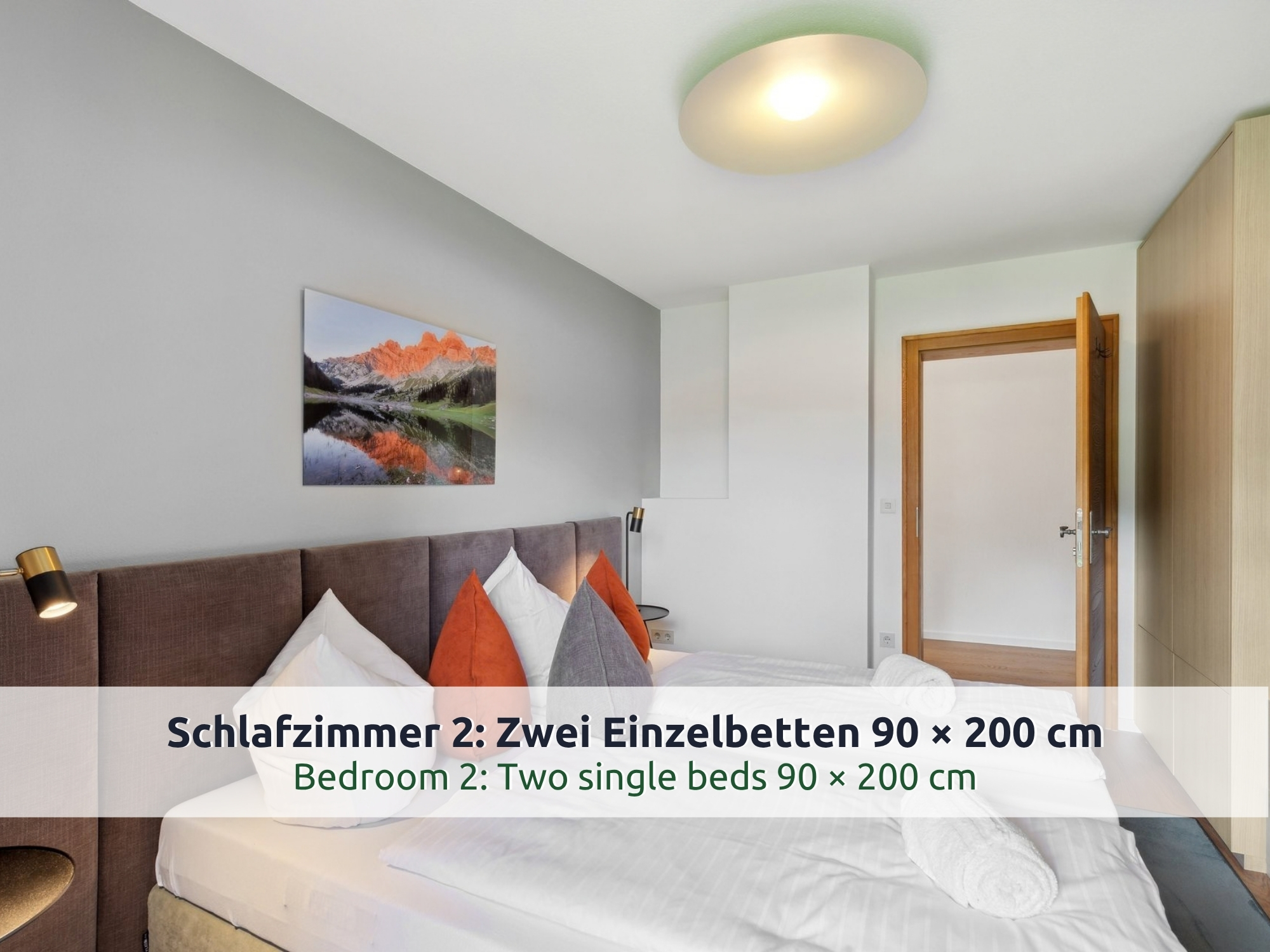 34 Villa Siegsdorf: zwei zusammengeschobene Einzelbetten mit braunem Polsterkopfteil, Bergbild und Kleiderschrank