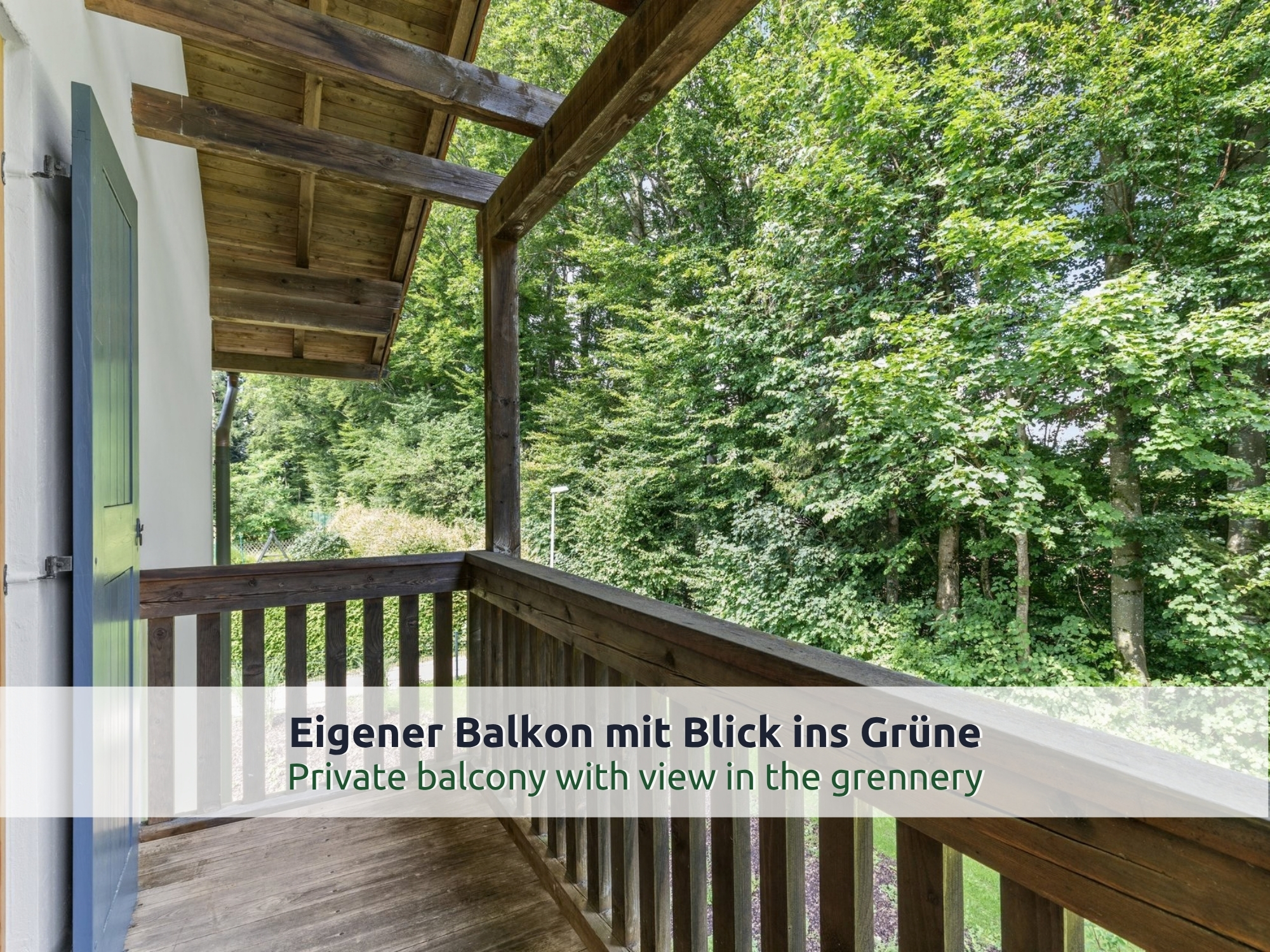 45 Villa Siegsdorf: überdachter Holzbalkon mit Blick in hohe Laubbäume und auf den Garten