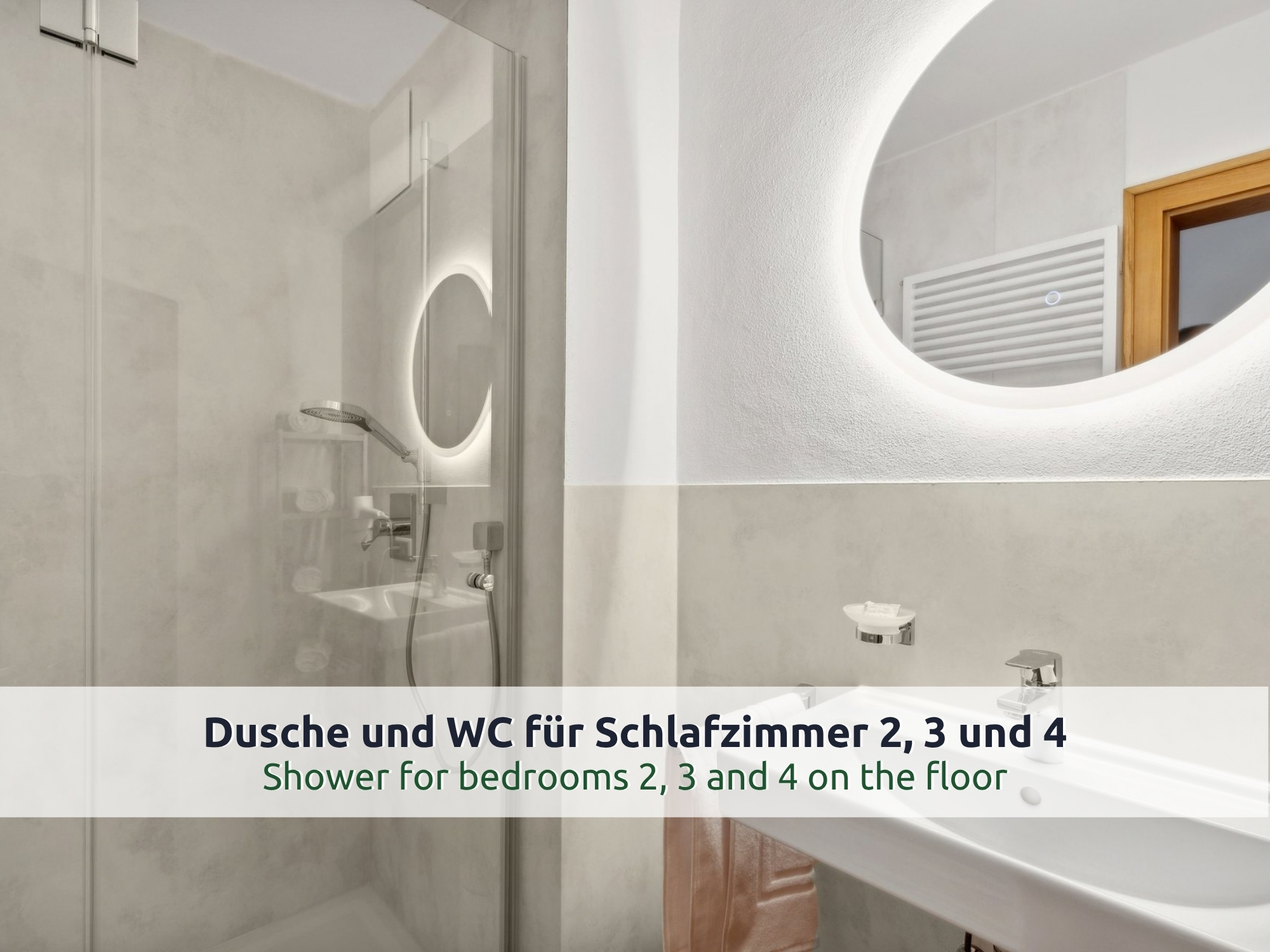 46 Villa Siegsdorf: modernes Duschbad mit Glasdusche, Regenbrause, beleuchtetem ovalem Spiegel und Waschbecken